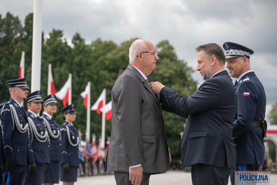 Na zdjęciu widoczny jest Pan Marcin Kierwiński - Minister Spraw Wewnętrznych i Administracji  oraz Komendant Główny Policji Pan gen. insp. Marek Boroń, podczas wręczania medalu Panu Piotrowi Żywicy.