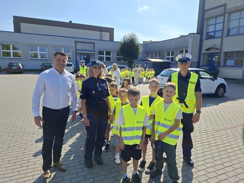 Na zdjęciu grupa dzieci wraz z policjantami i pracownikiem WORD