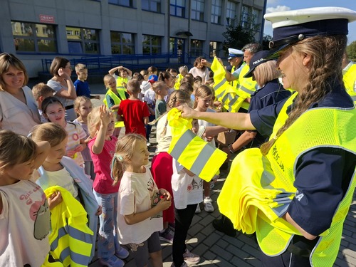 Na zdjęciu widoczny moment rozdawania dzieciom elementów odblaskowych
